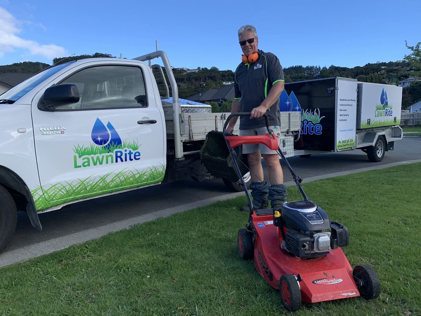Lawn Rite crew member posing in front of Lawn Rite Trailer.